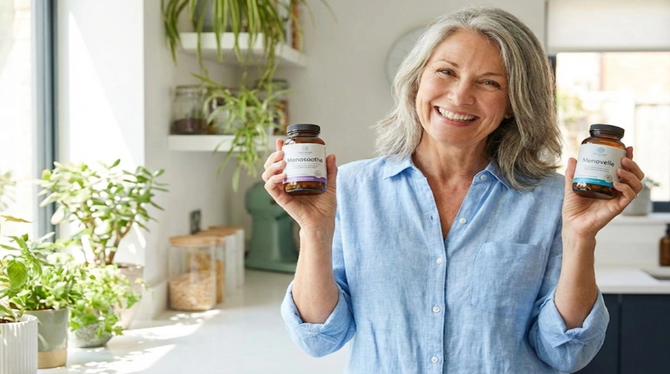 Happy woman holding MenoSoothe and Menovelle supplement bottles after finding menopause symptom relief